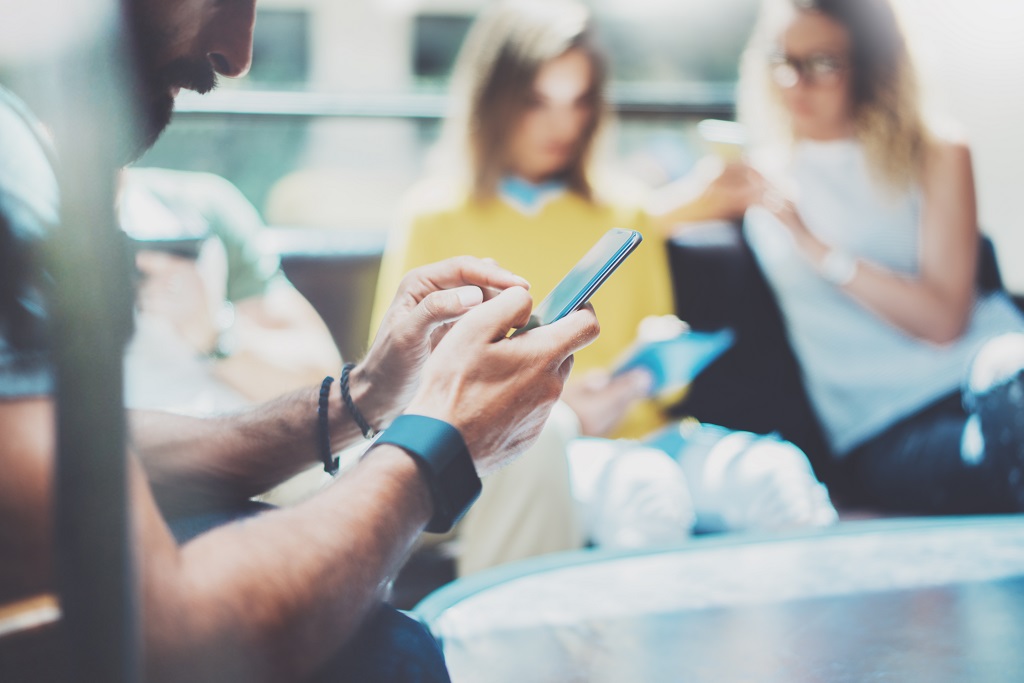 Bearded Hipster Man Using Modern Smartphone Hand.Teamwork Young Business People Gathered Together Discussing Creative Idea.Coworker Friend Brainstorm Meeting Discussion Working Office Startup Concept.