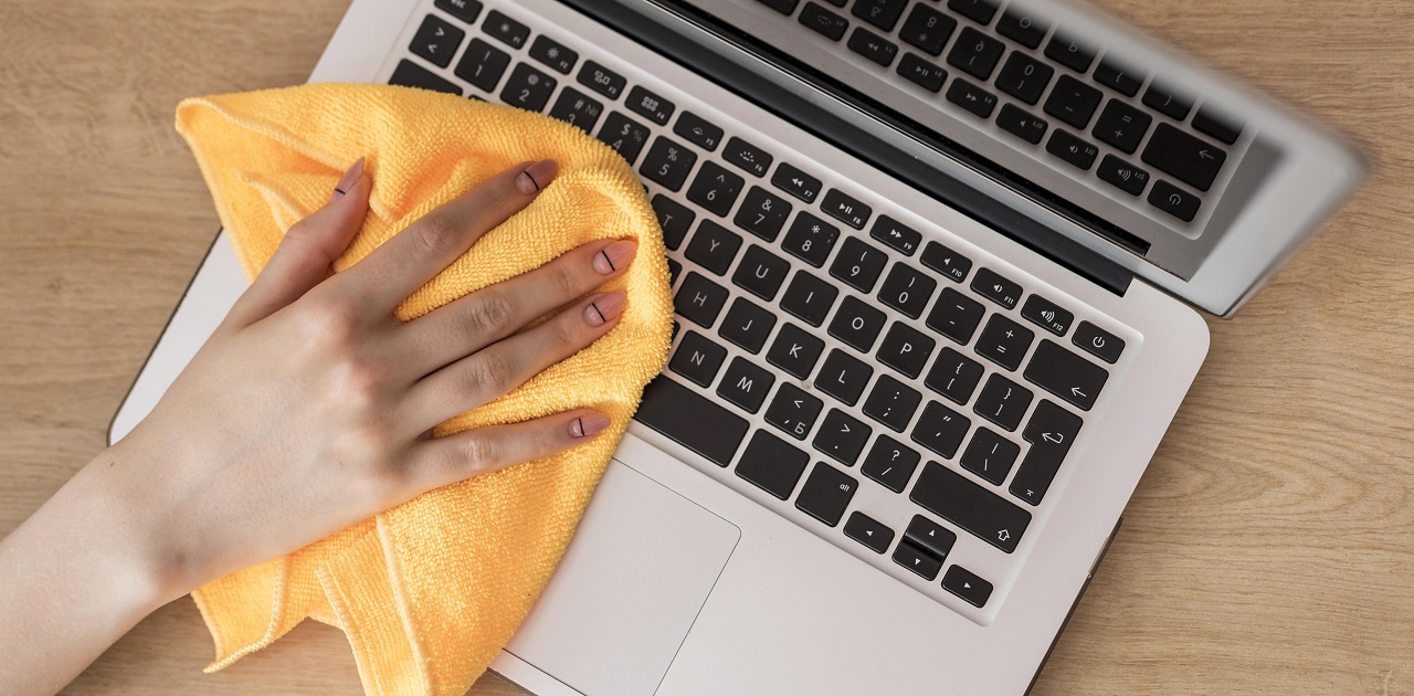 top-view-woman-cleaning-laptop-with-cloth top-view-woman-cleaning-laptop-with-cloth