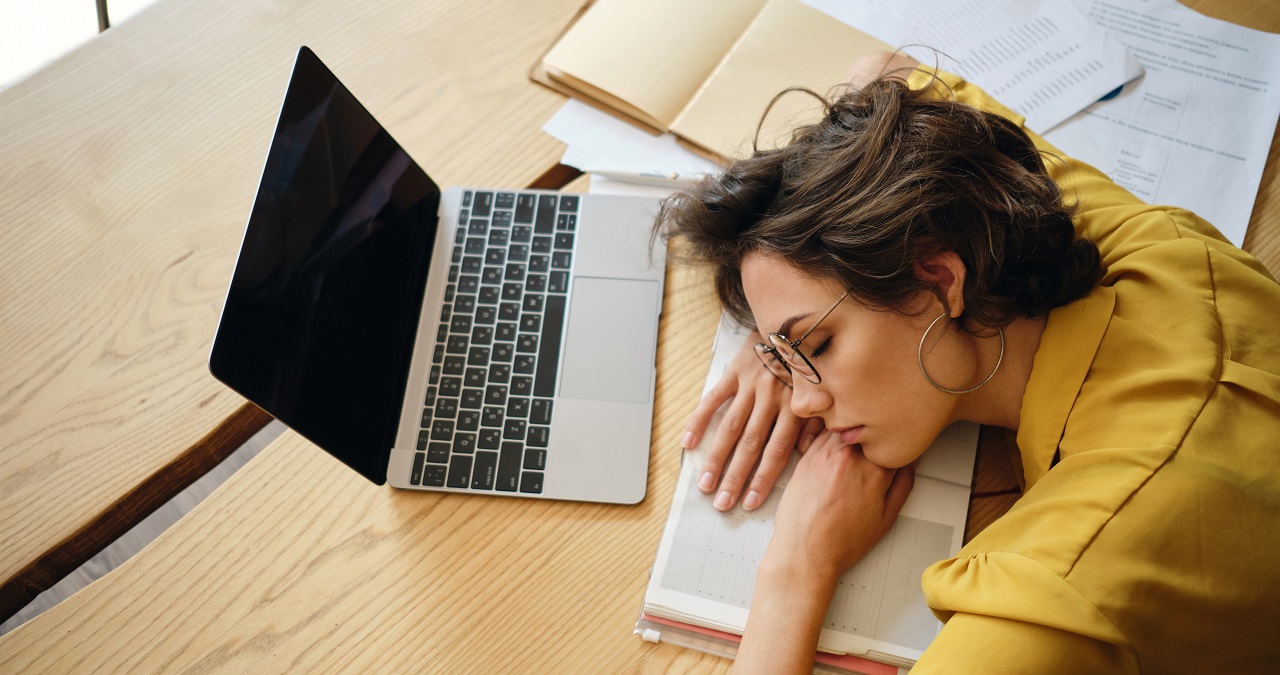 Top view of young tired woman dreamy asleep on desk with laptop Top view of young tired woman dreamy asleep on desk with laptop
