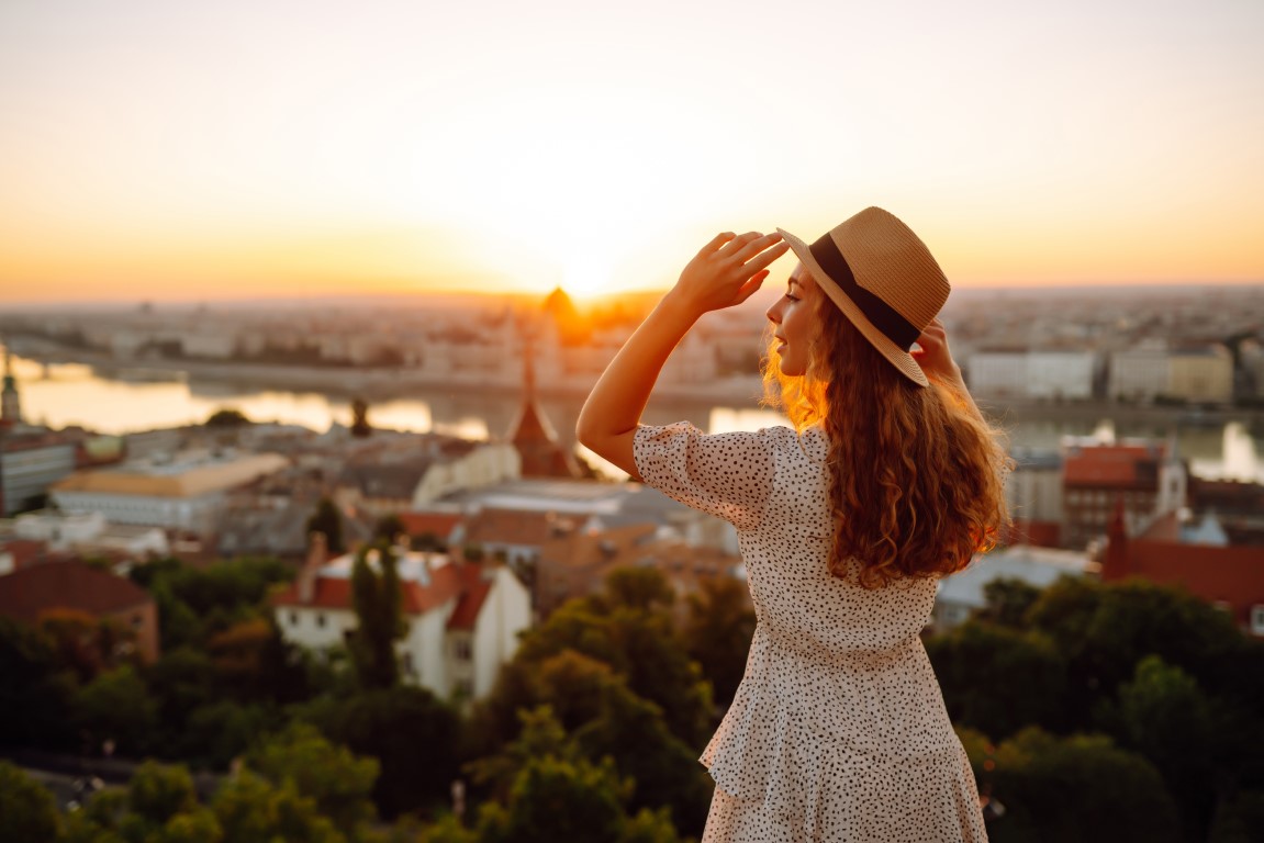 Young female tourist looking at panoramic view of the city at sunset. Lifestyle, travel, active life Young female tourist looking at panoramic view of the city at sunset. Lifestyle, travel, active life