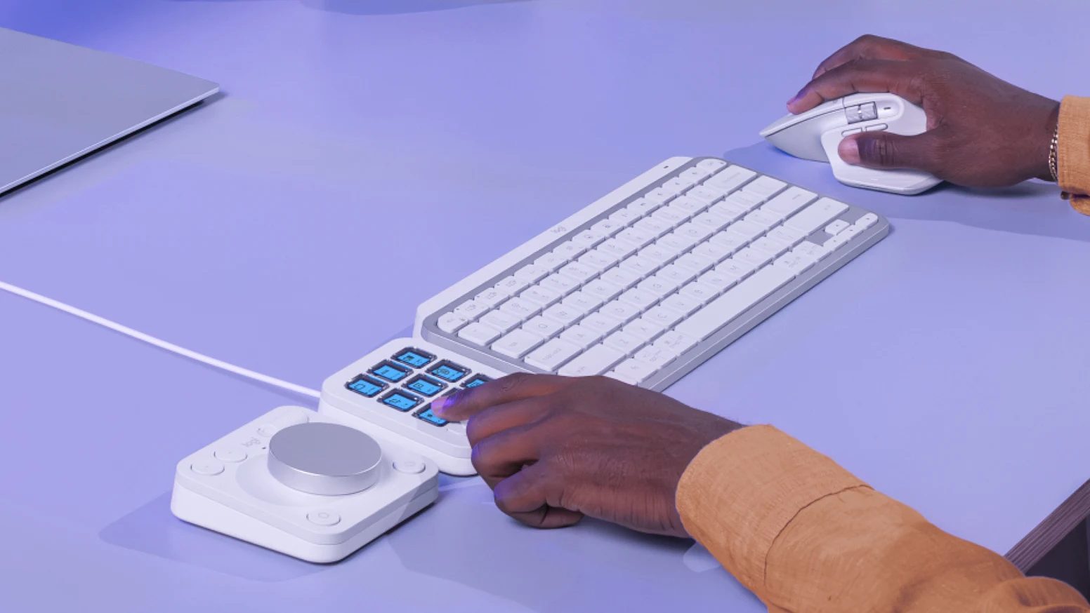 person using mx creative console and mx keys mini mac 1